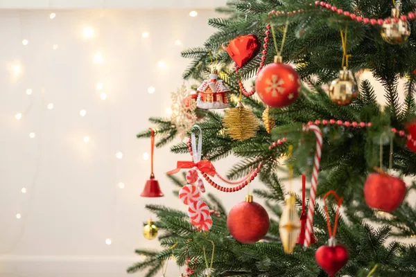 Árbol de Navidad decorado con juguetes dorados y rojos con fondo bokeh Imagen De Stock