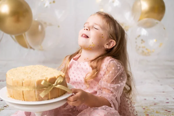 Mignon petit enfant fille manger gâteau d'anniversaire sans main et célébrer anniversaire — Photo