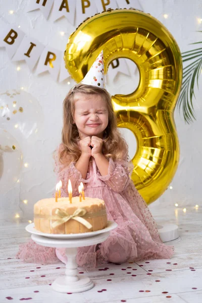 Linda niña soplando velas en pastel de cumpleaños y celebrando cumpleaños —  Fotos de Stock