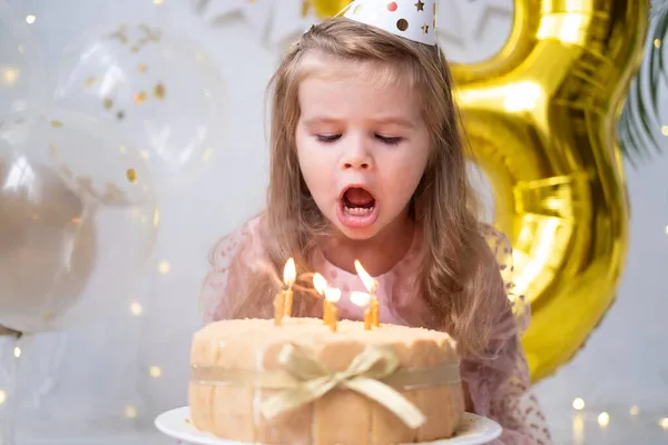 Roztomilé malé dítě dívka foukání svíčky na narozeninový dort a slaví narozeniny — Stock fotografie