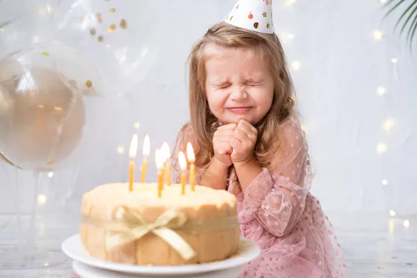 Mignon petit enfant fille souffler des bougies sur gâteau d'anniversaire et de célébrer anniversaire — Photo