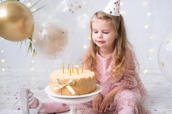 Menina bonito soprando velas no bolo de aniversário e celebrando aniversário — Fotografia de Stock