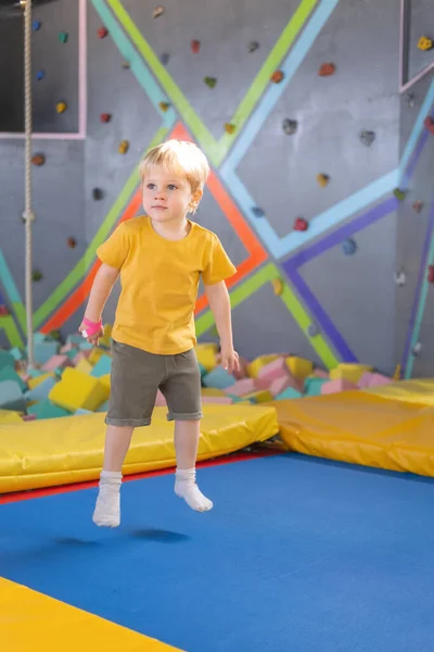 Słodkie blondynka mały chłopiec skacze w a trampolina park dla dzieci aktywność — Zdjęcie stockowe