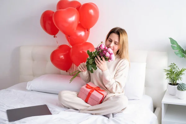 Mulheres bonitas segurando buquê de rosas cor-de-rosa na cama celebrando o dia dos namorados — Fotografia de Stock