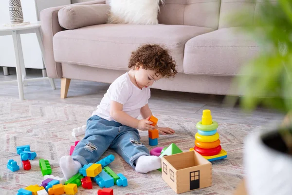 Enfant frisé fille jouer avec pyramide et constructeur à la maison. développement de la petite enfance — Photo