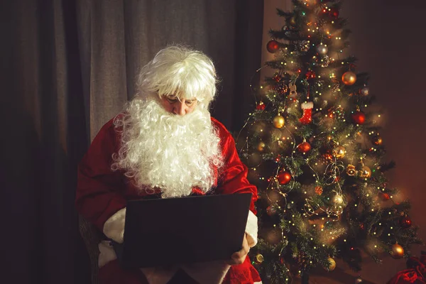 真正的圣诞老人在笔记本电脑上工作 家庭内部 在圣诞和新年来临之际 — 图库照片