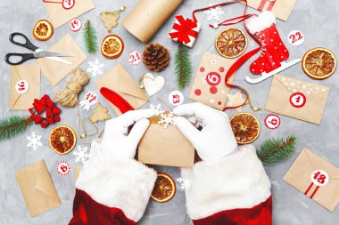 Noel Baba takvimi hazırlıyor. Çevre araçları çocuklar için hediyelerle dolu zarflar. Mevsimlik Noel geleneği. Düz yatış, üst görünüm.