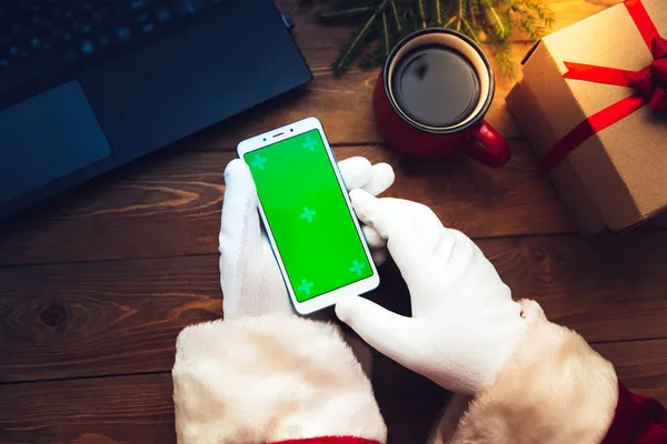 Jultomtens Handskar Håller Telefon Det Chromakey Bredvid Den Finns Laptop — Stockfoto