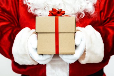 Noel Baba eldivenli kırmızı kurdeleli bir hediye kutusu tutuyordu.. 