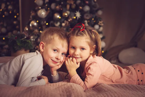 Děti Leží Posteli Dívají Kamery Vánoční Dekorace Čekání Dovolenou — Stock fotografie