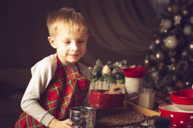 Çocuk mutfakta kurabiye hazırlıyor. Noel süsleri, aile gelenekleri, Noel yemeği, tatil arifesi.. 