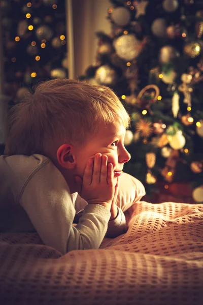 Niño Yace Cama Sobre Fondo Árbol Navidad Decoraciones Navidad Esperando — Foto de Stock