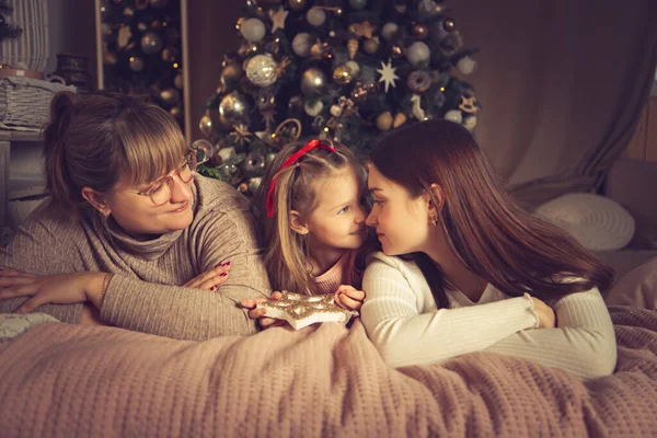 母と娘はベッドに横になっている クリスマスの装飾 休日を待っている — ストック写真