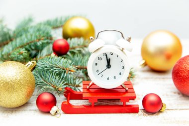 Alarm saati, köknar dalları ve ahşap bir arka planda Noel topları. Noel arkaplanı veya kartpostal. 