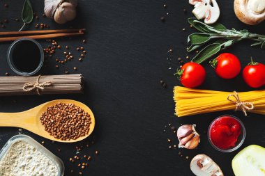 İtalyan spagettisi Japon sobasına karşı. Siyah zemin, düz zemin, kopyalama alanı. Gıda arkaplanı. 