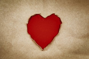 Kalp şeklinde bir delik var. Geri dönüşümlü kraft kağıdı. Klasik, grunge tarzı, kopyalama alanı. Sevgililer Günü konsepti.