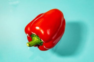 Mavi arka planda sulu kırmızı dolma biber. 