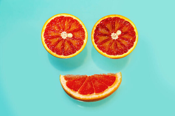 Whole and sliced juicy red oranges on a blue background. Food background. 