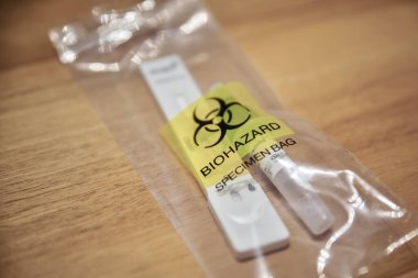 Closeup of a used corona test kit in a plastic bag. clipart