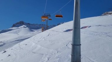 Alman Alplerinde bir kayak merkezinde kayak asansörü. Güneşli bir kış gününde kayak pistinde kayakçılar.