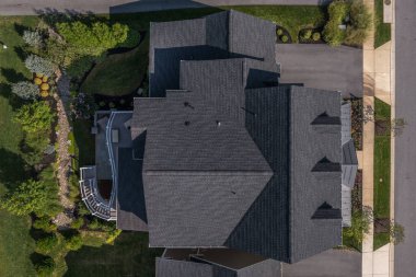 Kompleks bir kalça ve vadi manzaralı tepeden aşağıya doğru üç yatakhanelik yeni bir Amerikan lüks aile evi inşaatı.