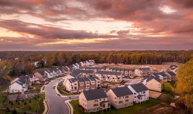 Maryland 'deki büyük çok birimli Amerikan gayrimenkul gelişiminin havadan görüntüsü ana caddede tek kişilik evler, arka planda fışkıran evler ve hala boş olan bir sürü ev.