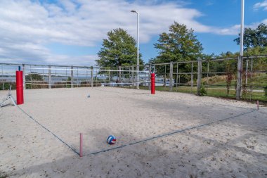 Sonbaharda tüm tatilciler gittiğinde terk edilmiş bir plaj voleybolu sahasında mavi beyaz plaj topu