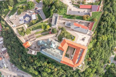 Orta Slovakya 'daki kırmızı kiremitli çatı piskopos sarayı ile Nitra kalesi ve kilisesinin tepeden aşağı görüntüsü büyük top kaleleri olan tepenin üstünde.