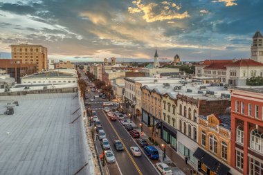 Broughton Caddesi bakılacak dükkanlarla ve yapılacak şeylerle dolu. Georgia 'nın tarihi Savannah ticaret merkezi. Dramatik günbatımı gökyüzü.