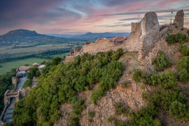 Balaton Gölü yakınındaki Szigliget Kalesi 'nin havadan görünüşü. Yeni restore edilmiş duvarları, kapı kulesi, saray binası günbatımı renkli gökyüzü.