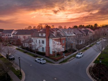 Maryland 'de birbirine yakın, dramatik gökyüzü ile inşa edilmiş lüks Amerikan aile evleri olan yeni bir emlak gelişimi topluluğunun hava günbatımı manzarası.