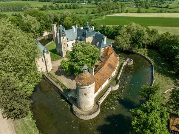 Berry ve Bourbonnais sınırındaki tarihi Bannegon kalesinin hava manzarası, heybetli kalesi, asma köprüsü, ve trapezoidal güçlendirilmiş bir muhafaza, su dolu hendek