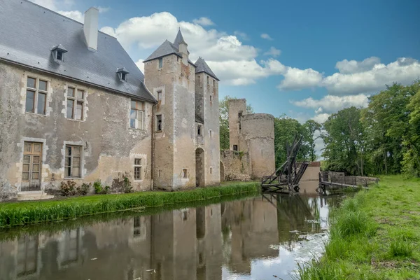 Fransa 'daki tarihi anıt Bannegon şatosunun su dolu hendeğin üzerinde ahşap bir köprü, heybetli bir kale, asma köprü ve trapezoidal güçlendirilmiş bir muhafaza manzarası