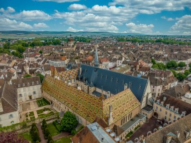 Beaune, Burgundy Fransa 'daki Hotel de Dieu ortaçağ Gotik bakımevinin verniklenmiş güzel kiremit polikrom çatılarının hava manzarası.