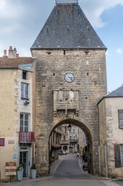 Ortaçağ şehir kapısı, saatli, kubbeli geçit, Fransa 'nın kuzey merkezindeki Bourgogne-Franche-Comt, Yvonne' daki ortaçağ Noyers sur Serein 'inde tebeşir taşı kareli granitik kaldırımlar.