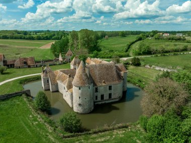 Buranyeure Kalesi 'nin havadan görünüşü hendekle çevrili antik bir su kalesi sadece yeşil bir çayırın ortasında dikdörtgen kuleleri olan bir köprüden geçebilir.