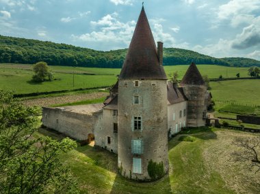 Brancion France yakınlarındaki Chateau de Nobles 'ın havadan görünüşü, yuvarlak kuleleri restore edilmiş, rönesans sarayı tepeleri üzerinde.