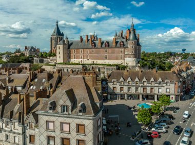 Aerial panoramic view of Gien castle in the Loire valley with a bridge stretching over the river, blue cloudy sky. Renaissance Chateau made of limestone and brick with decorative architecture clipart