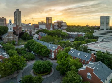 New Brunswick, New Jersey şehir merkezinin hava manzarası dramatik günbatımı gökyüzü alçak apartmanlar ve ilk ıslah edilmiş kilise, yüksek binalar, otoparklar.