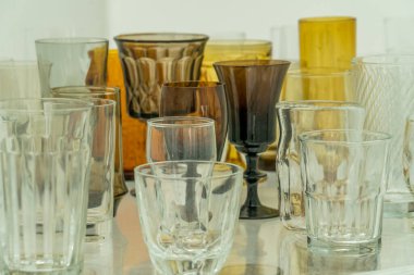 Assortment of various shapes and size yellow cups and glasses on a shelf