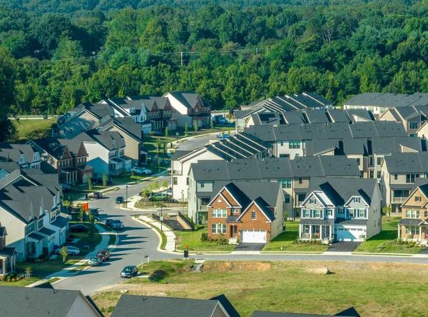 Close up aerial view of a curving street with newly built single family homes real estate in a new East Coast USA neighborhood