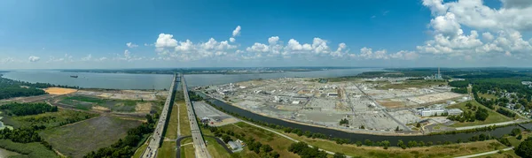Aerial view of the Delaware Memorial Bridge spanning across the Delaware river connecting to the New Jersey turnpike with a giant chemical plan in the background