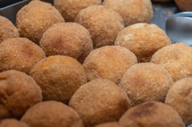 Arancini 'nin yakın görüntüsü, İtalyan dolgulu pirinç topları, ekmek kırıntılarıyla kaplı ve Sicilya' dan kızartılmış.