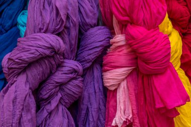Lüks yumuşak kumaş mor, kırmızı, pembe renkli atkılar pazarda