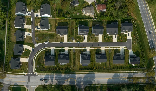 Aerial top down view of new neighborhood with single family houses drive way off the main street