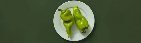 Pimientos verdes sobre plato blanco sobre fondo verde. —  Fotos de Stock