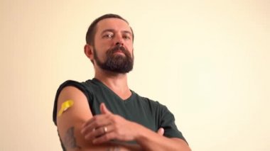 Omzundaki aşıdan sonra bandajlı bir adam baş parmağını kaldırdı.