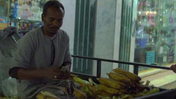 Mutlu adam akşam sokakta mısır satıyor. — Stok video