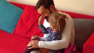 Genç baba kızını giydirir, okul sabahı konsepti.