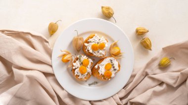 Beyaz tabakta meyve veren Ricotta Crostini.